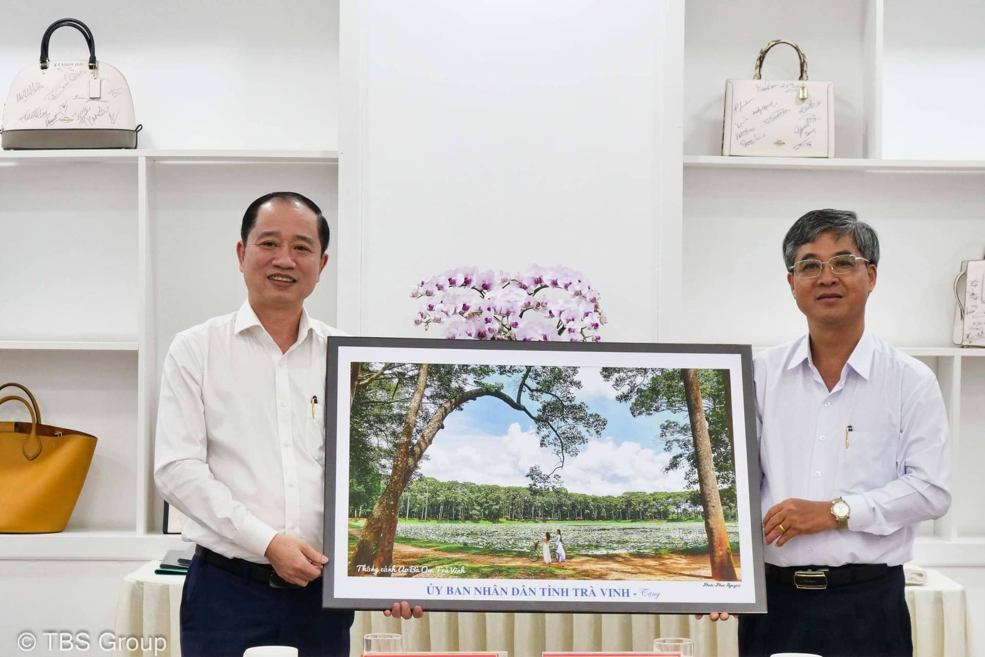Đồng chí Châu Văn Hòa (phải), Tỉnh ủy viên, Phó Chủ tịch UBND tỉnh tặng bức tranh ao Bà Om cho ông Nguyễn Anh Tuấn, Phó Tổng Giám đốc TBS Group.